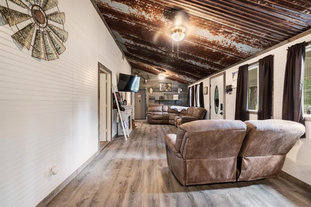 28 Private Road Sumner, TX 75486 - Photo 4 of 17 Living area with vaulted ceiling, wood finished floors, and wood walls