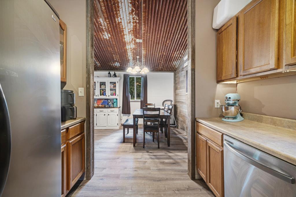 28 Private Road Sumner, TX 75486 - Photo 6 of 17 Kitchen with appliances with stainless steel finishes, brown cabinetry, decorative light fixtures, and light countertops