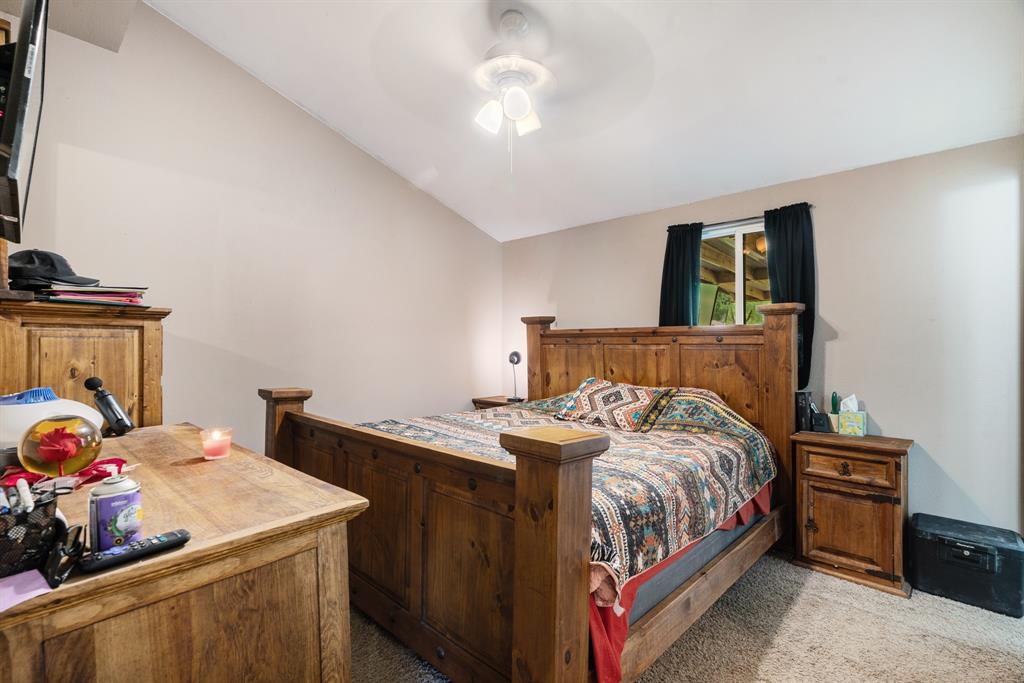 28 Private Road Sumner, TX 75486 - Photo 8 of 17 Carpeted bedroom with vaulted ceiling and ceiling fan