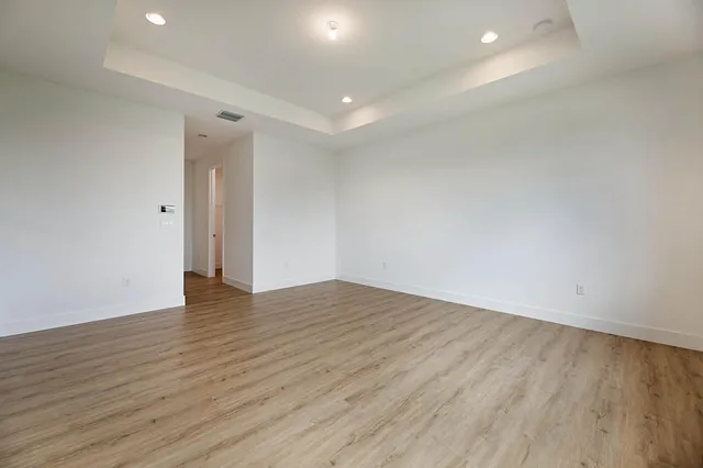 a view of an empty room with wooden floor