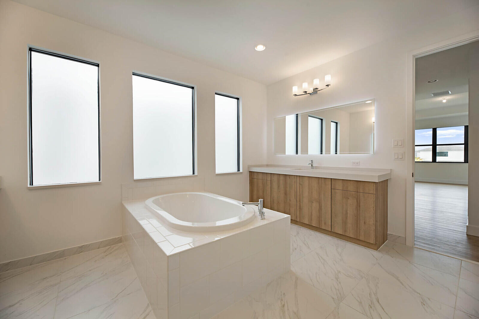 17062 Watersprite Lakes Road Boca Raton, FL 33496 - Photo 27 of 42 a bathroom with a tub a sink and mirror