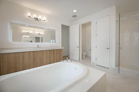 a spacious bathroom with a bathtub a shower a sink and a mirror