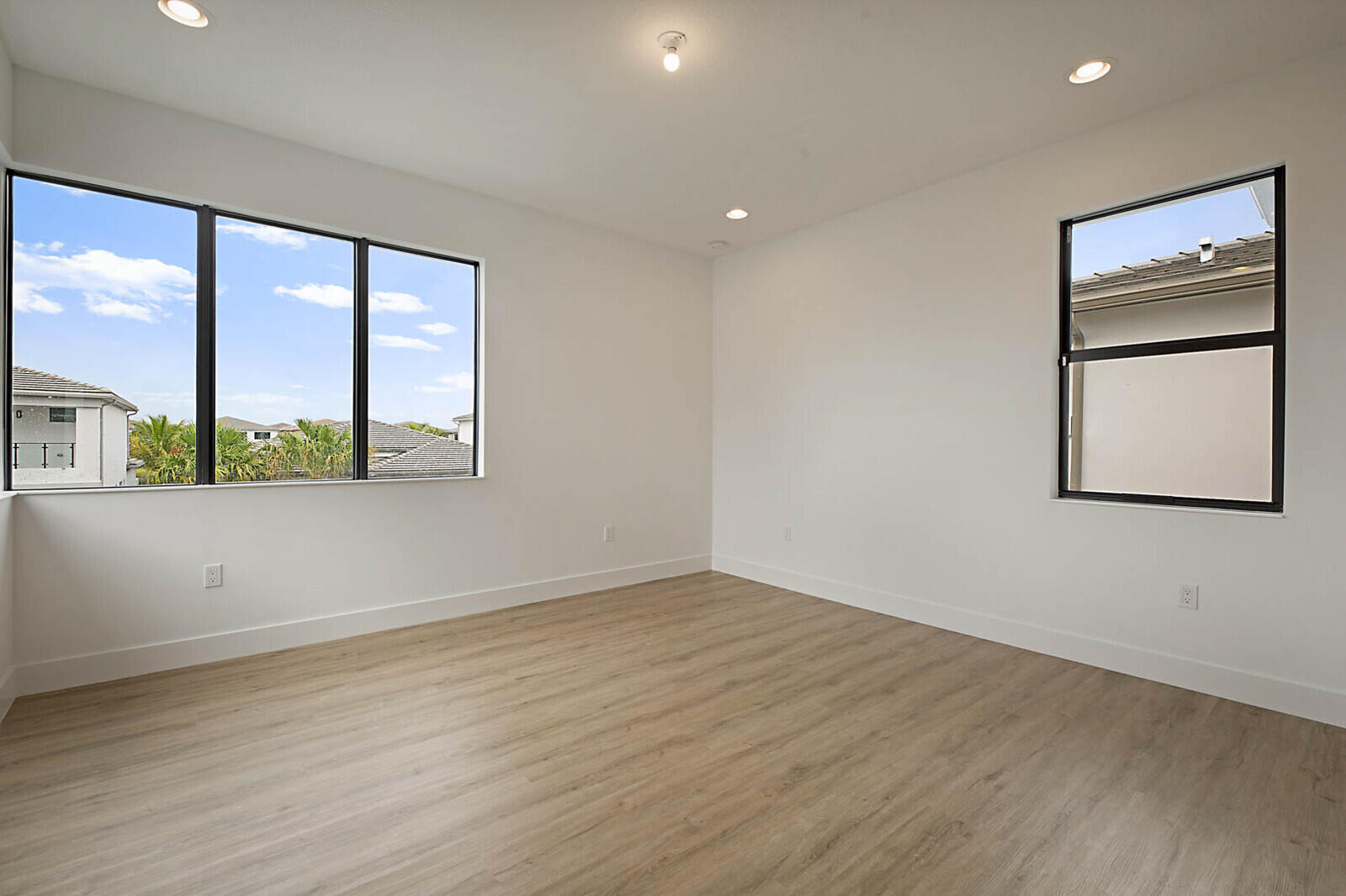 17062 Watersprite Lakes Road Boca Raton, FL 33496 - Photo 32 of 42 an empty room with wooden floor and windows