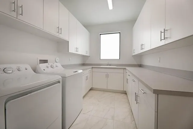 a kitchen with cabinets appliances a sink and a window