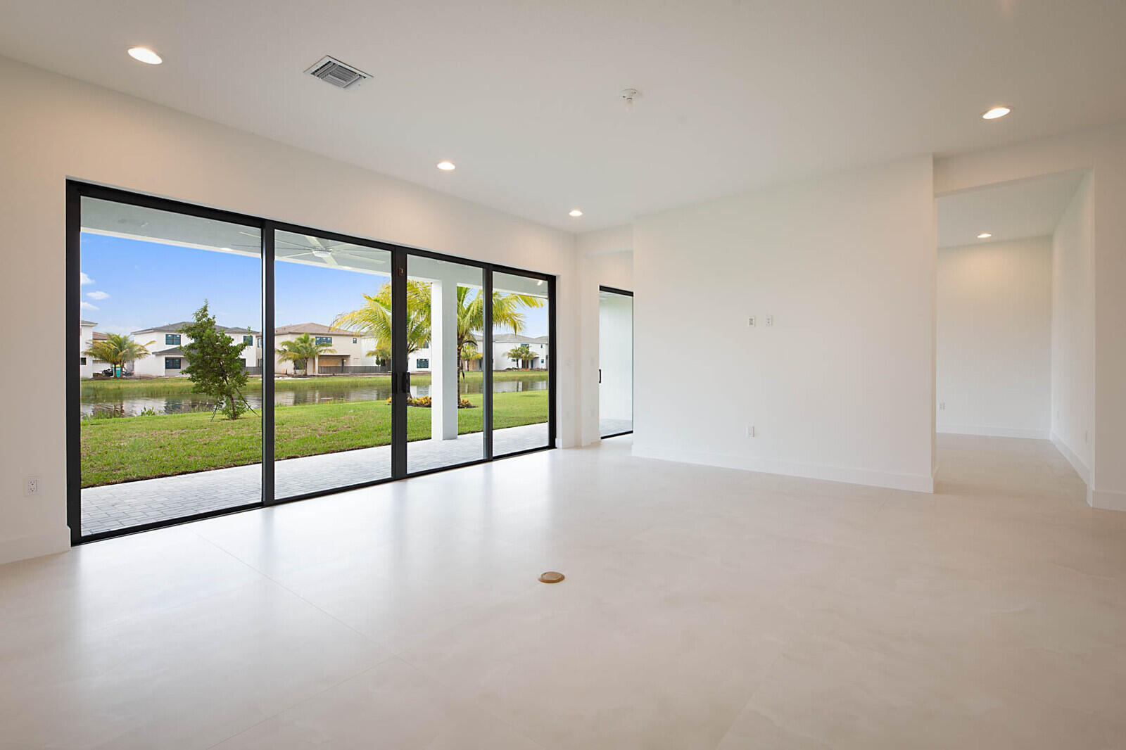 17062 Watersprite Lakes Road Boca Raton, FL 33496 - Photo 4 of 42 a view of an empty room with wooden floor and floor to ceiling window