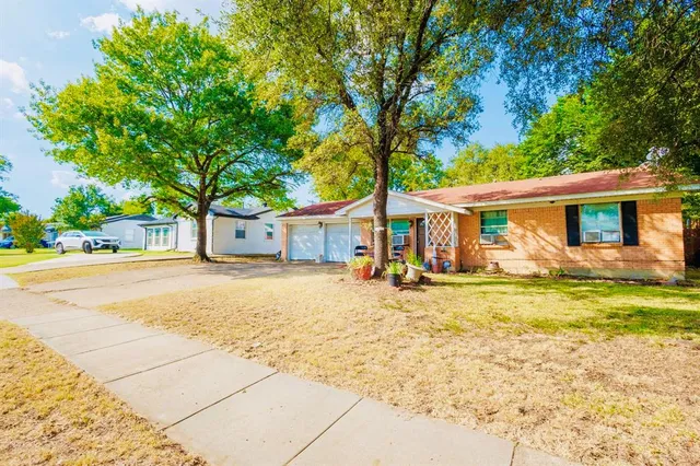 a front view of a house with a garden and trees