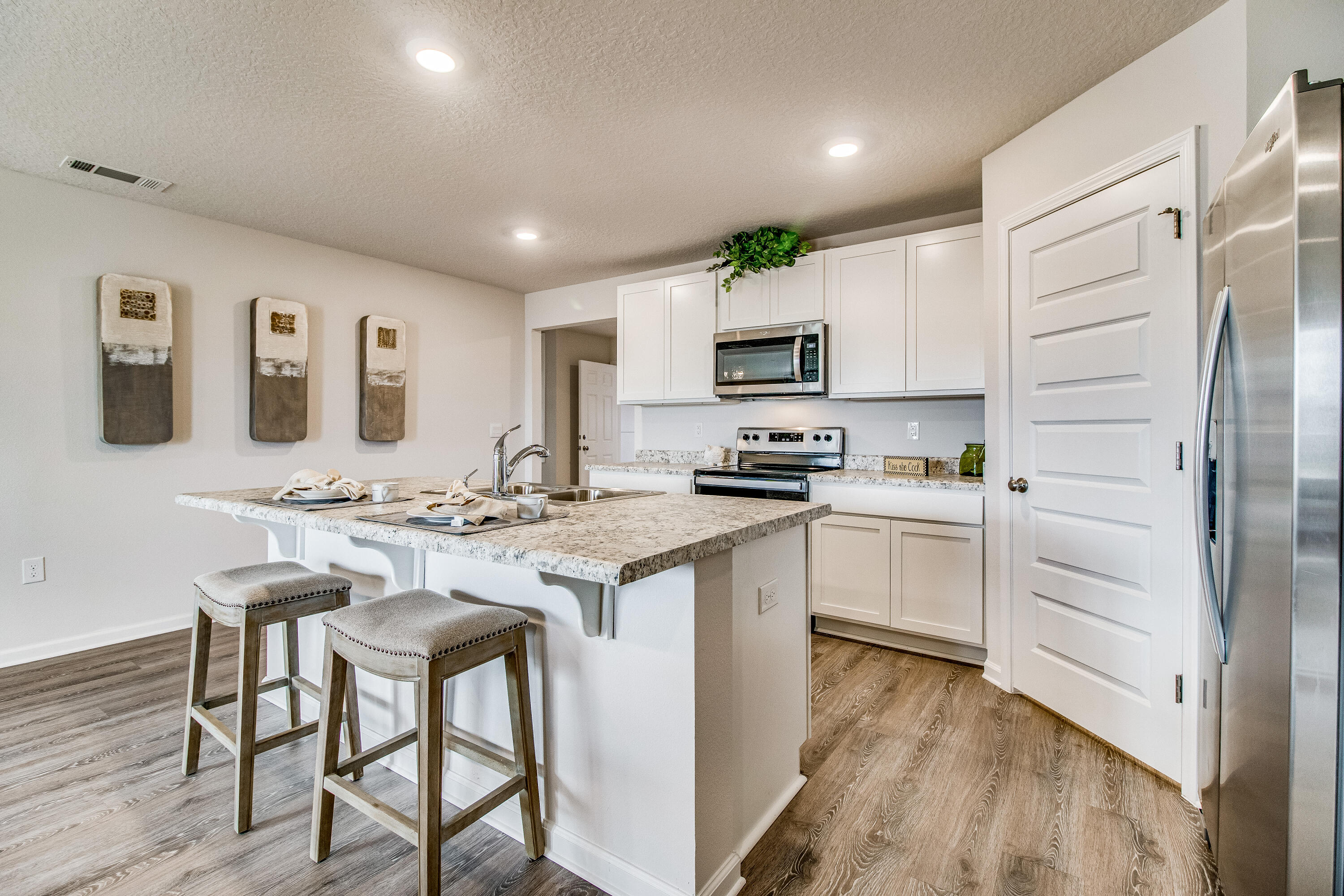 6629 Spyglass Hill Road Laurel Hill, FL 32567 - Photo 7 of 26 a kitchen with white cabinets and stainless steel appliances