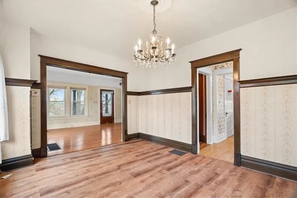 a view of a livingroom with wooden floor and chandelier
