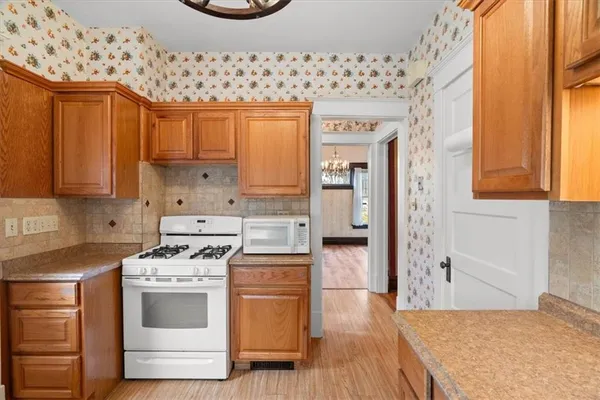 a kitchen with stainless steel appliances a stove a sink and a refrigerator with wooden floor