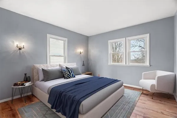 a bedroom with a large bed and wooden floor