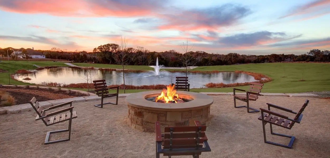 1908 Woolsey Way Leander, TX 78641 - Photo 33 of 36 Gather around the warming fire pit and admire serene pond views under a dramatic sunset sky.