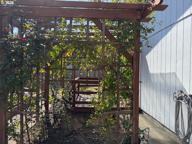 2164 24th Street Florence, OR 97439 - Photo 13 of 42 a backyard of a house with wooden fence and large trees