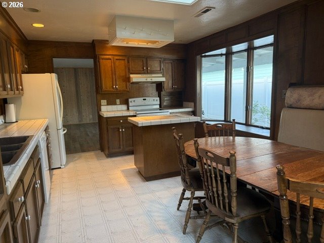2164 24th Street Florence, OR 97439 - Photo 24 of 42 a kitchen with kitchen island a stove a table and chairs in it