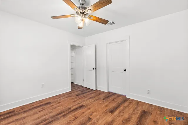 an empty room with wooden floor and door