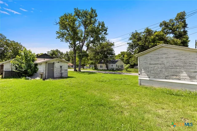 a view of a house with backyard and tree
