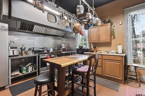 a kitchen with stainless steel appliances granite countertop a refrigerator and table
