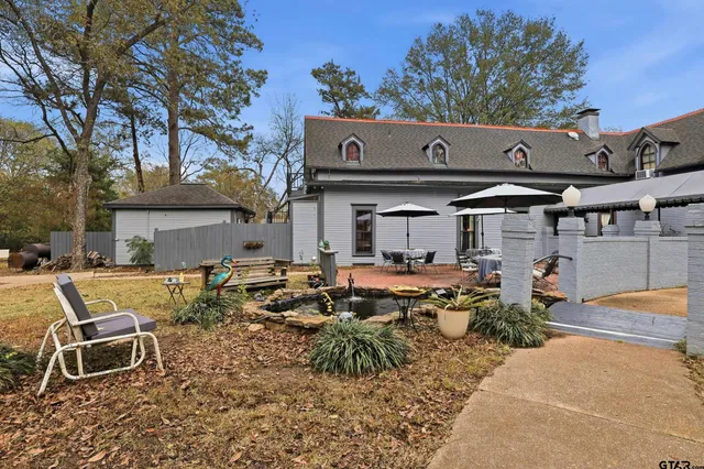 a view of backyard with table and chairs under an umbrella