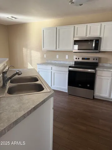a kitchen with sink a microwave and cabinets