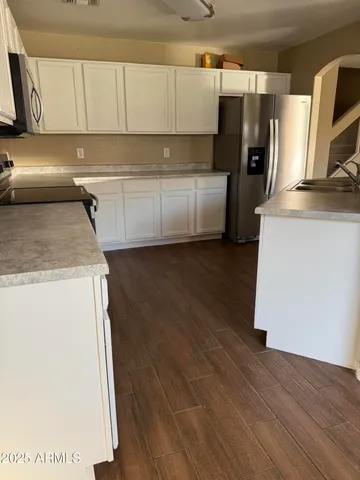 a kitchen with granite countertop a refrigerator sink and stove