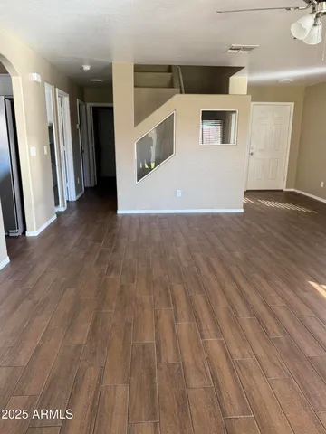 a view of a hallway with wooden floor and front door