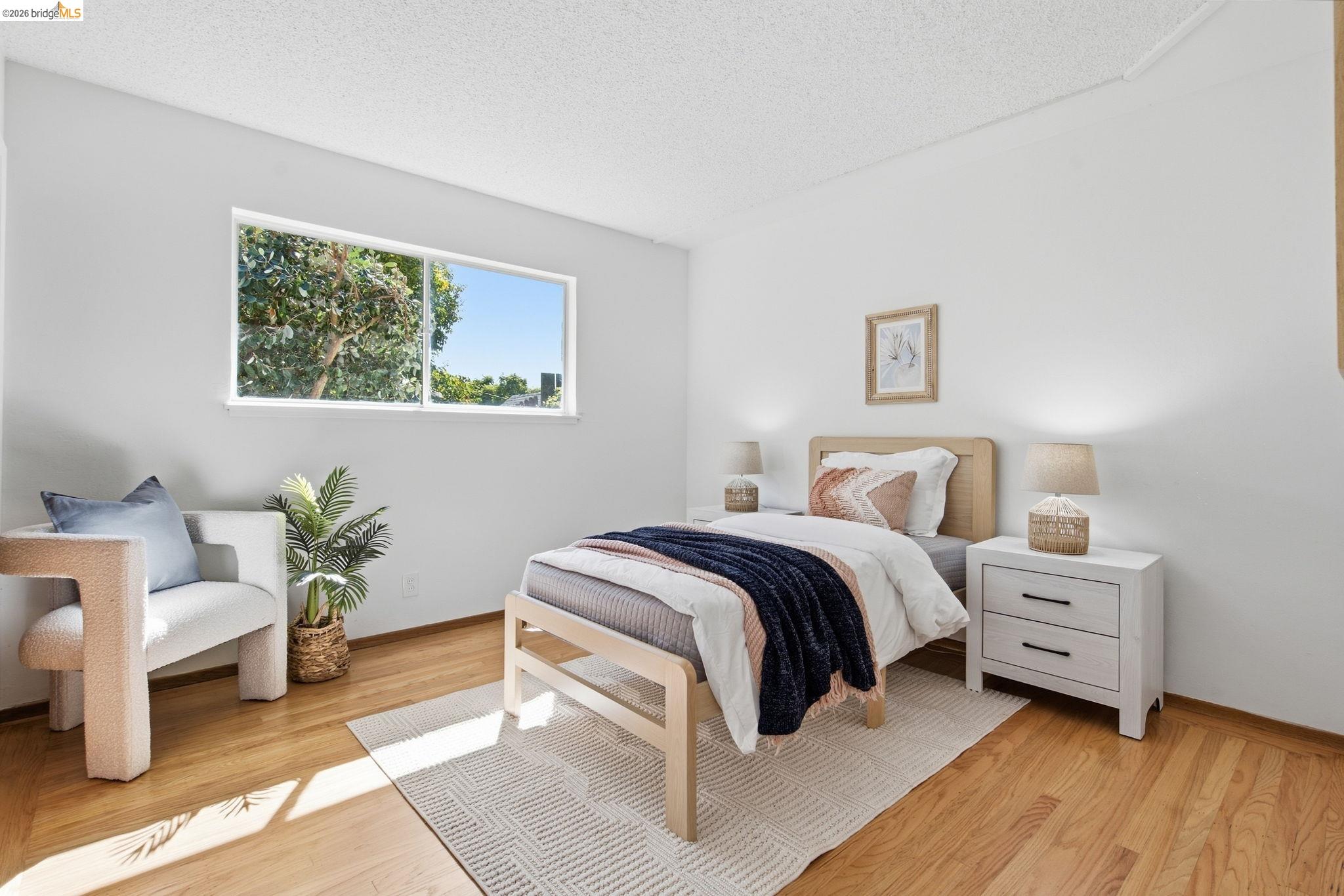 4522 Santa Rita Road El Sobrante, CA 94803 - Photo 18 of 58 Wood-finish flooring throughout, white walls, and a large horizontal window providing natural illumination