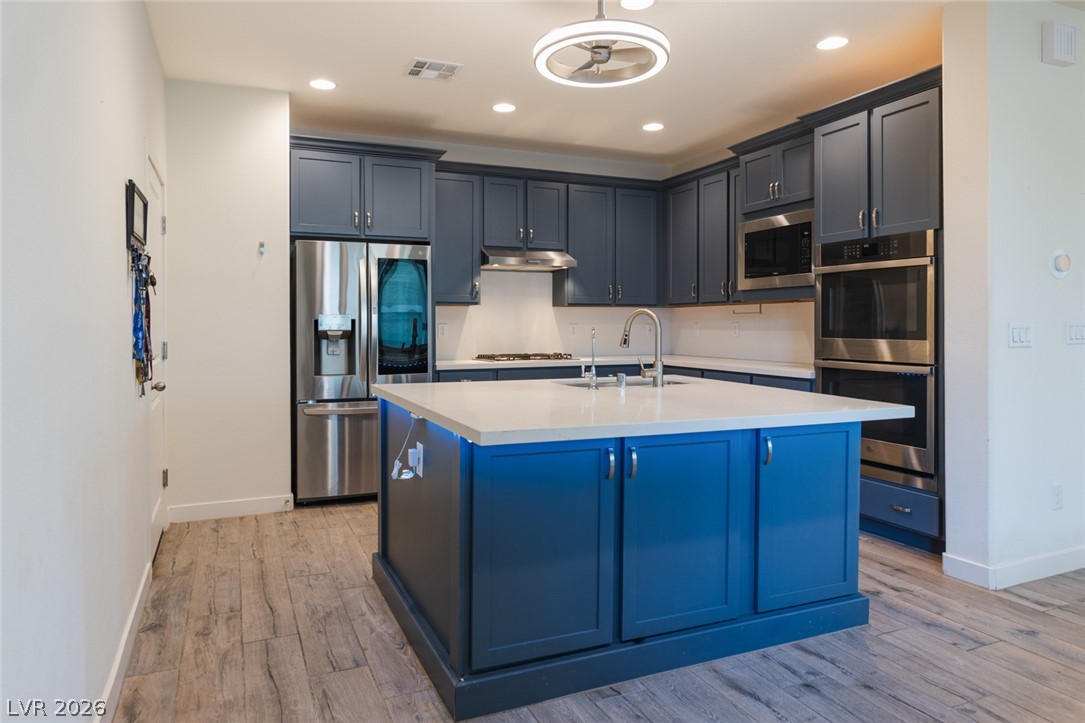 920 East Sunset Road Henderson, NV 89011 - Photo 8 of 33 Culinary excellence awaits in this modern kitchen featuring a central island and stainless steel appliances.