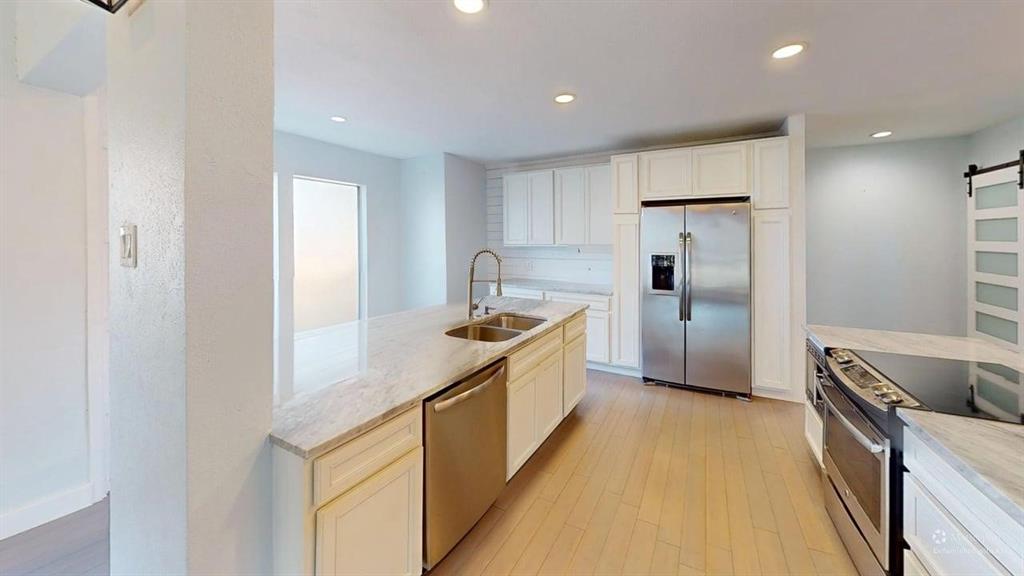 5805 Ranger Drive Rockwall, TX 75032 - Photo 3 of 24 a kitchen with stainless steel appliances granite countertop a refrigerator and a sink