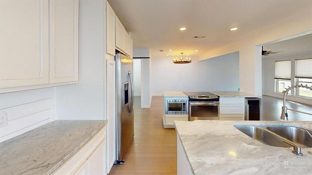 5805 Ranger Drive Rockwall, TX 75032 - Photo 4 of 24 a kitchen with stainless steel appliances kitchen island granite countertop a refrigerator and a sink