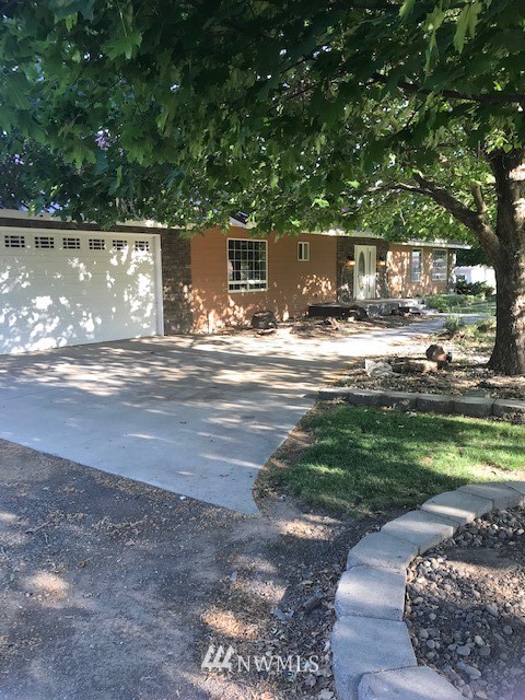 91 Hideaway Road Yakima, WA 98908 - Photo 2 of 25 a view of a patio with table and chairs a barbeque with potted plants and large trees