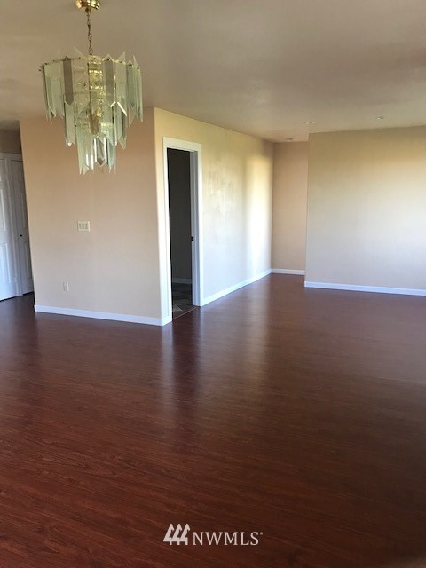 91 Hideaway Road Yakima, WA 98908 - Photo 16 of 25 an empty room with wooden floor and chandelier