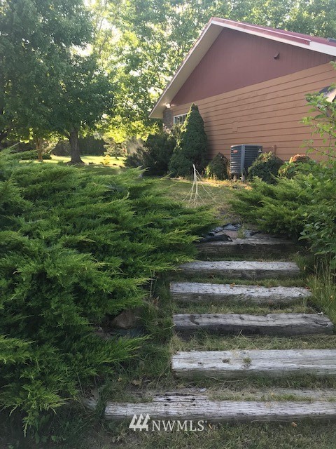 91 Hideaway Road Yakima, WA 98908 - Photo 3 of 25 a backyard of a house with plants and large trees