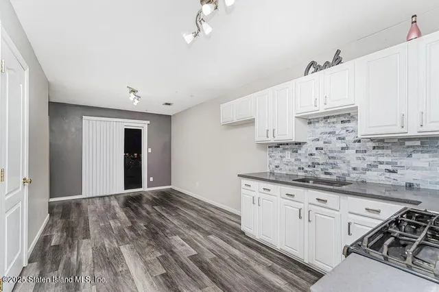 a kitchen with granite countertop a sink cabinets and stainless steel appliances