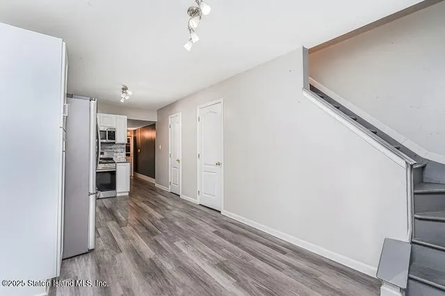 a view of a kitchen with a refrigerator and a stove top oven