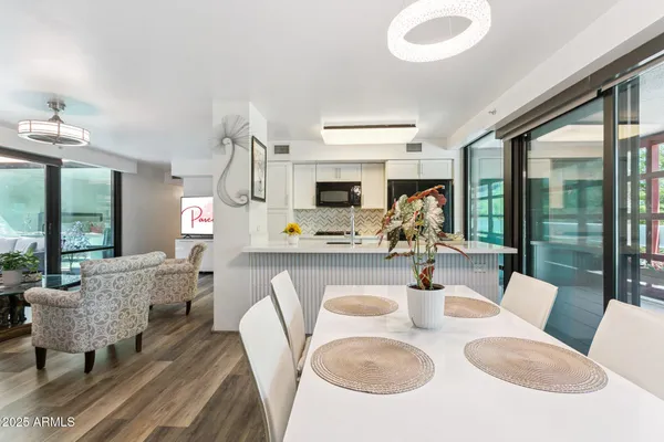 a dining room with furniture a rug a fireplace and a chandelier
