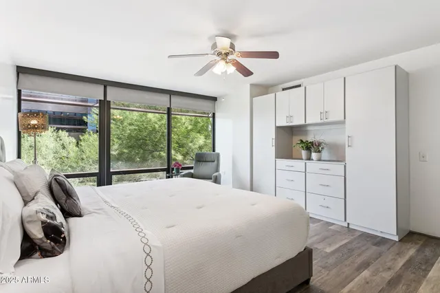 a bedroom with a bed and a large window