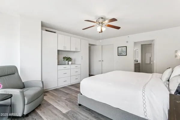 a spacious bedroom with a bed a couch and dresser