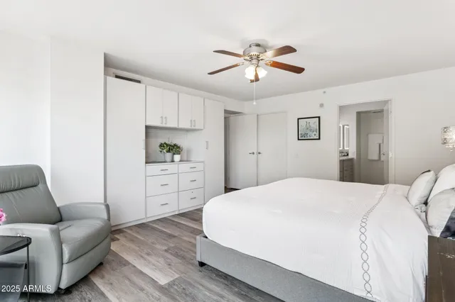 a spacious bedroom with a bed a couch and dresser