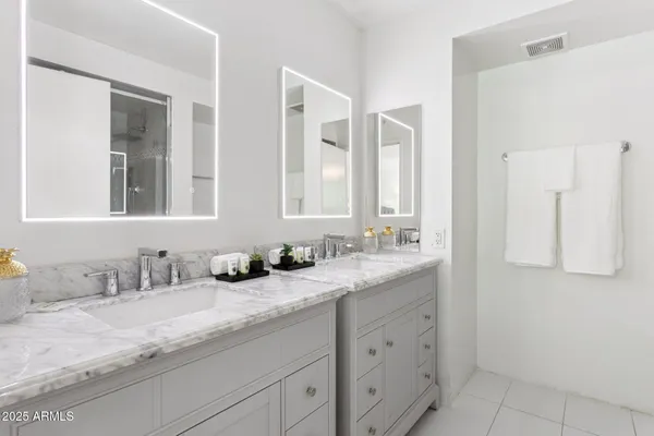 a bathroom with double sink and a mirror