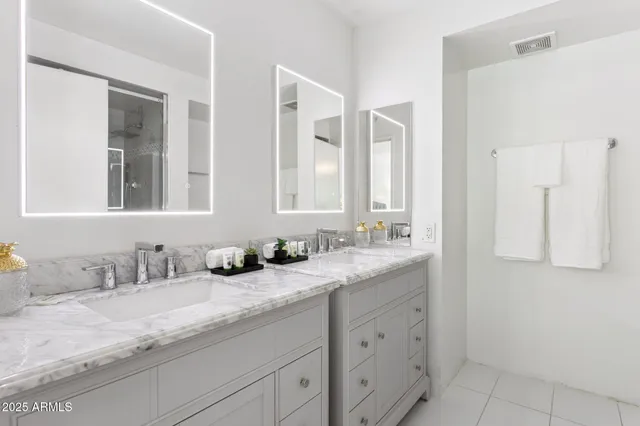a bathroom with double sink and a mirror