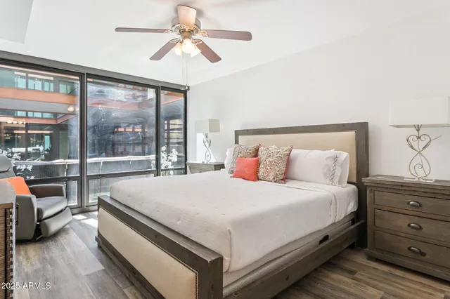 a bedroom with a large bed and a chandelier fan