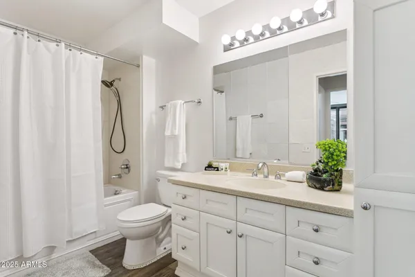 a bathroom with a sink vanity mirror and toilet
