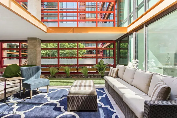 a living room with furniture a rug and a large window
