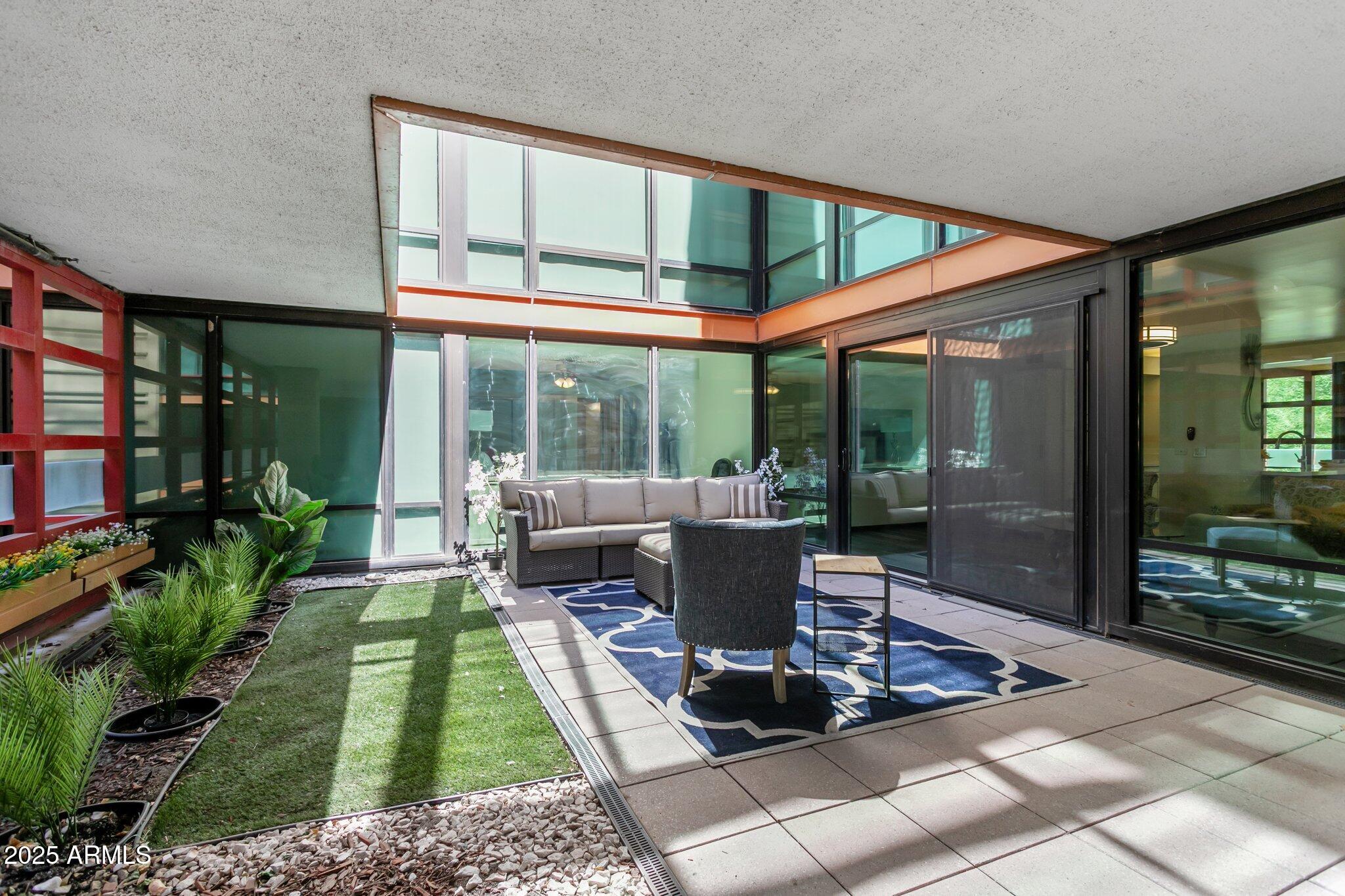 4808 North 24th Street, Unit 208 Phoenix, AZ 85016 - Photo 24 of 31 a view of a patio with table and chairs potted plants and floor to ceiling window