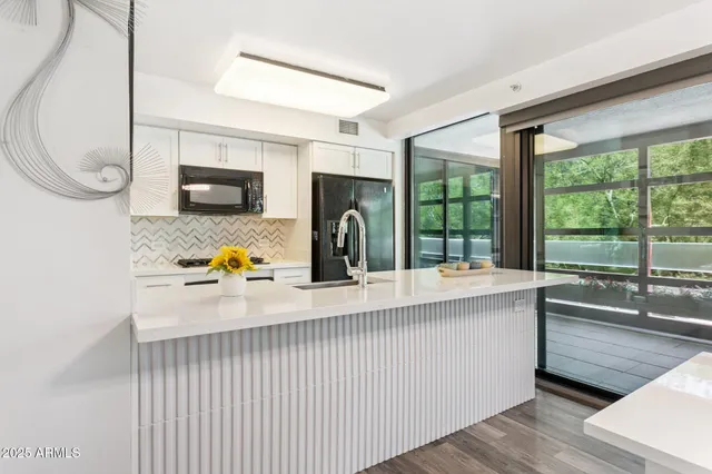 a kitchen with a sink a counter top space and stainless steel appliances