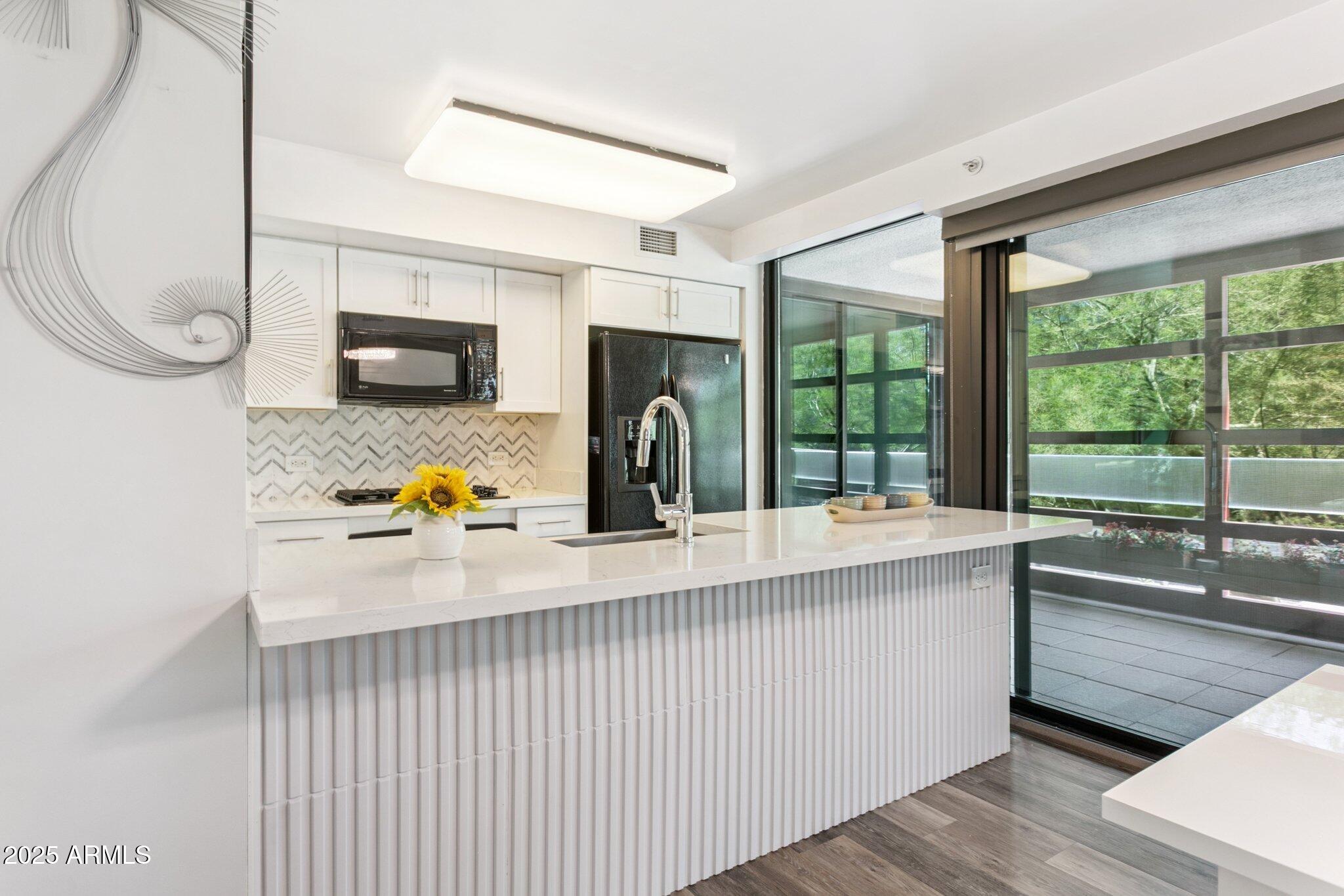 4808 North 24th Street, Unit 208 Phoenix, AZ 85016 - Photo 5 of 31 a kitchen with a sink a counter top space and stainless steel appliances