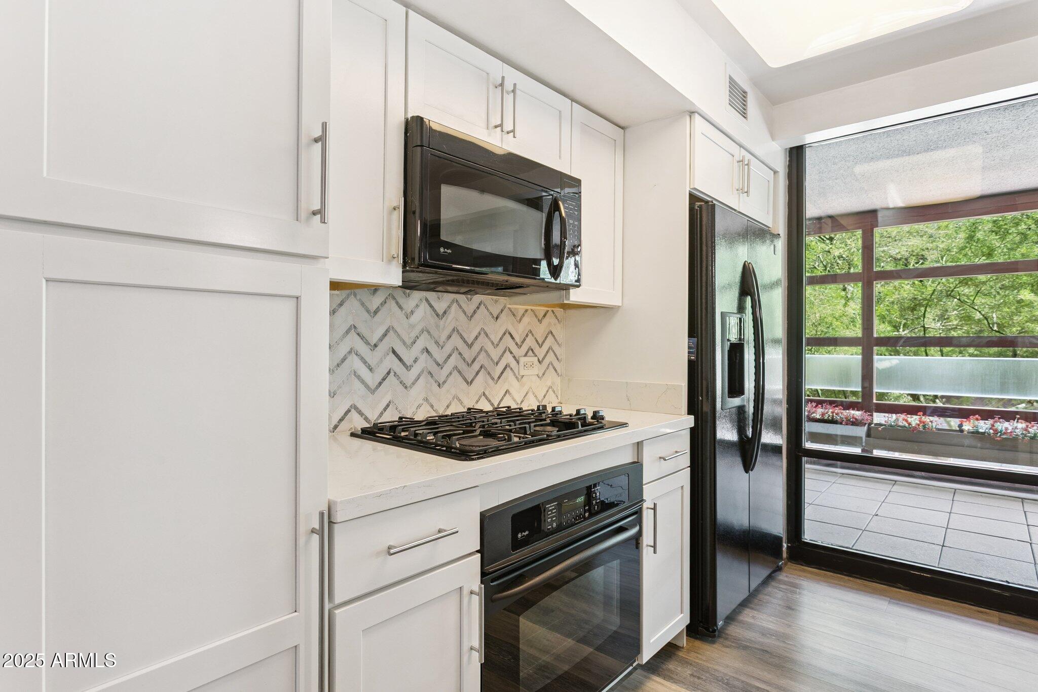 4808 North 24th Street, Unit 208 Phoenix, AZ 85016 - Photo 6 of 31 a kitchen with a stove and a microwave