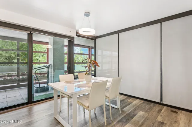 a view of a dining room with furniture large windows and wooden floor