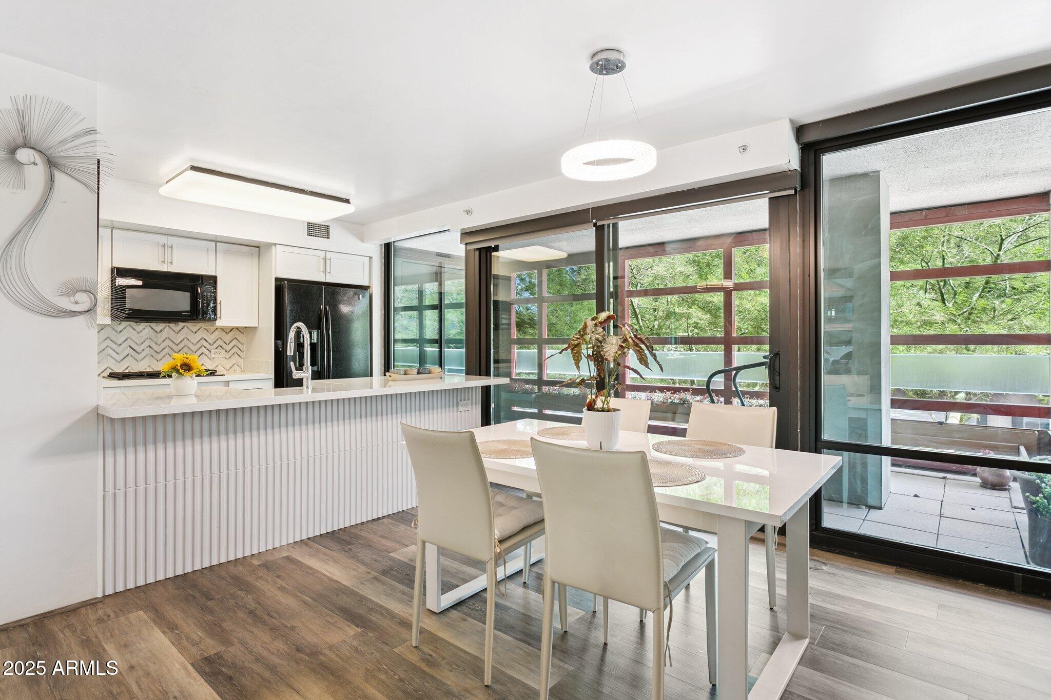 4808 North 24th Street, Unit 208 Phoenix, AZ 85016 - Photo 9 of 31 a view of a dining room with furniture a chandelier and wooden floor