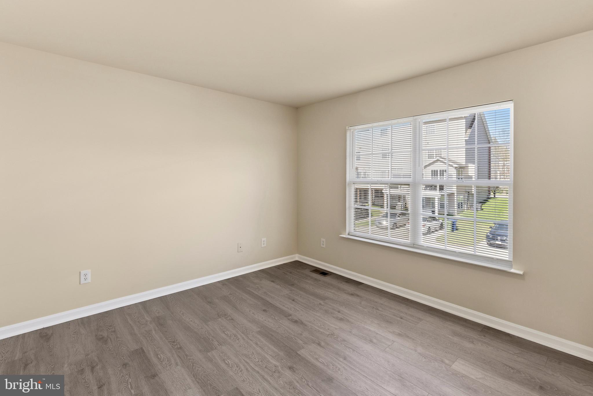 4704 Denview Way Baltimore, MD 21206 - Photo 14 of 42 an empty room with wooden floor and windows