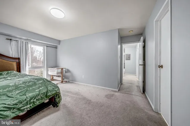 a bedroom with a bed and large windows